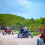 group of buggy vehicles riding on dusty countryside road during extrim tourist trip